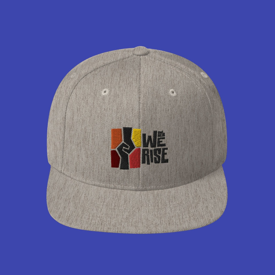 heather grey snapback hat with the Wright museum's And Still We Rise exhibit logo embroidered on it