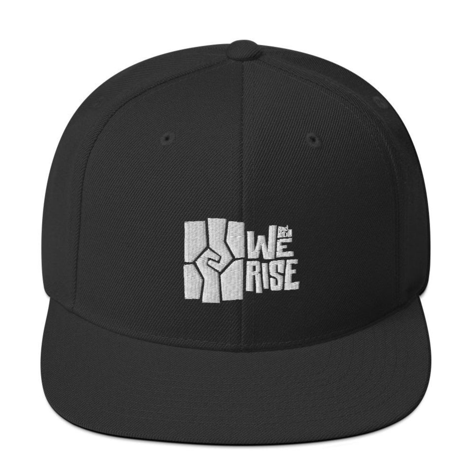 black snapback hat with the Wright museum's And Still We Rise exhibit logo embroidered in white 