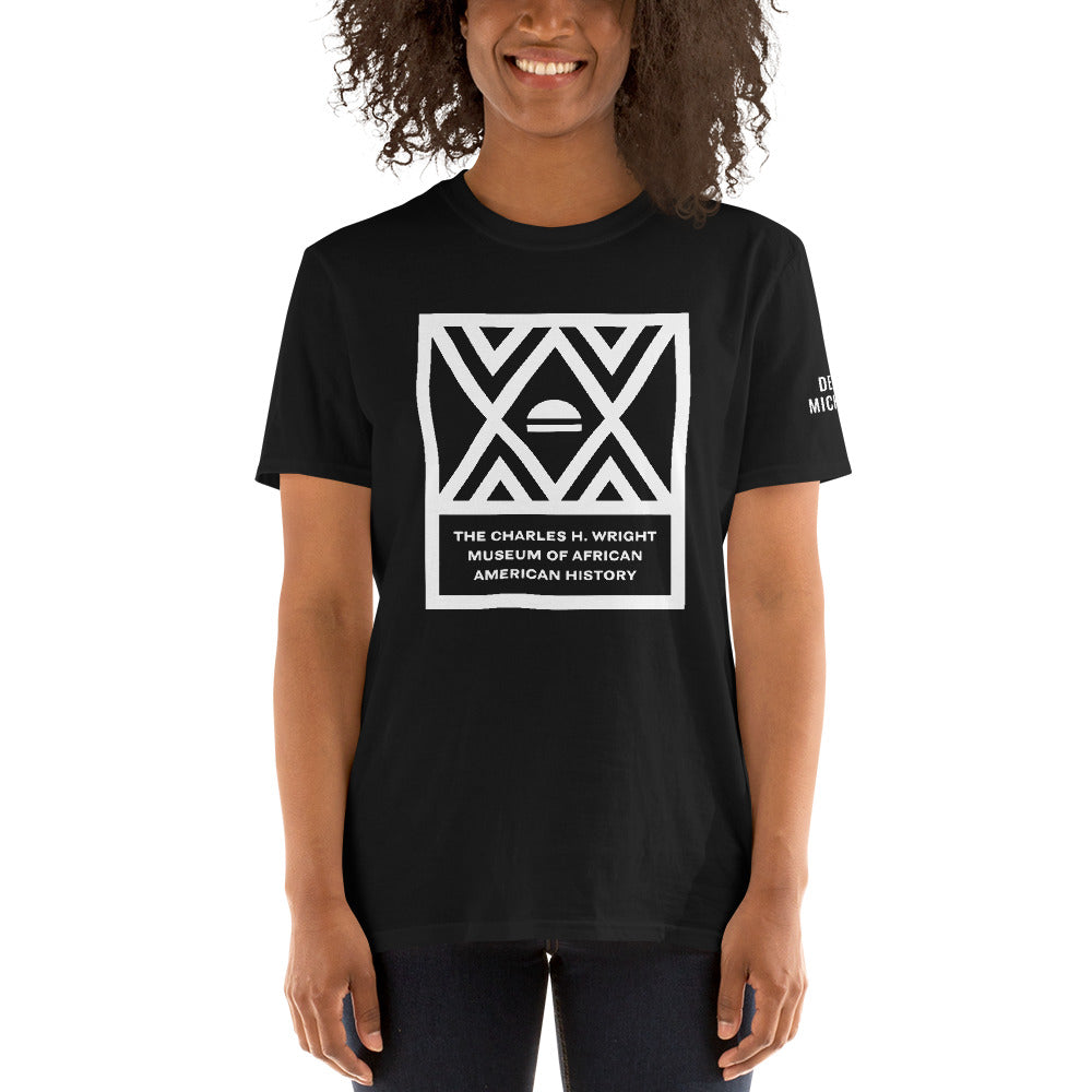 African American woman wearing the logo of the Charles H. Wright Museum emblazoned , in white, on the front of a black, cotton t-shirt.